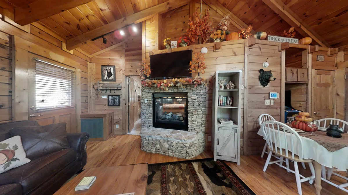 This image highlights the living room’s stacked-stone fireplace, wooden accents, and a dining table decorated for a gathering. The scene exudes celebration and togetherness, reflecting moments spent around the fire or sharing meals after a day of adventure.